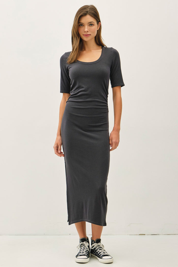 woman wearing a fitted charcoal gray midi dress with short sleeves and side slits, paired with black high-top sneakers