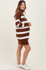 woman wearing a brown and white striped maternity sweater dress, showcasing her baby bump