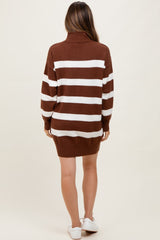 woman wearing a brown and white striped oversized sweater dress, showing a relaxed fit and a turtleneck, with no visible baby bump