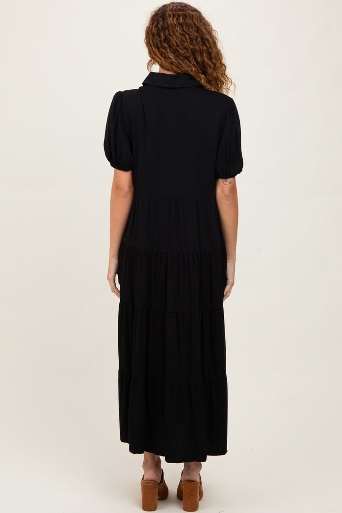 woman wearing a black tiered maxi dress with puff sleeves, shown from the back