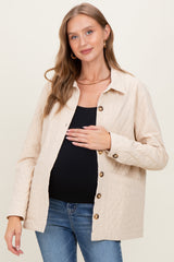 woman wearing a beige quilted maternity jacket and holding her baby bump