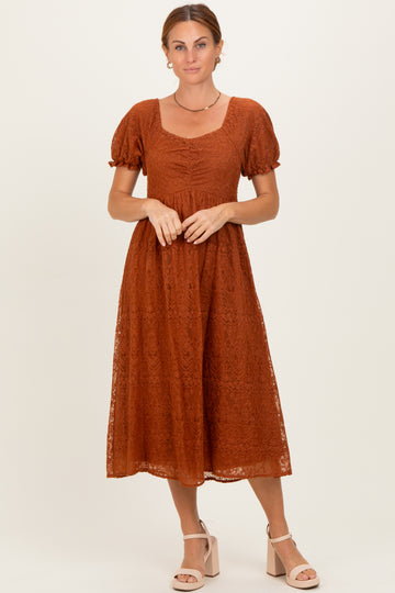 woman wearing a rust lace midi dress with short puff sleeves and a square neckline