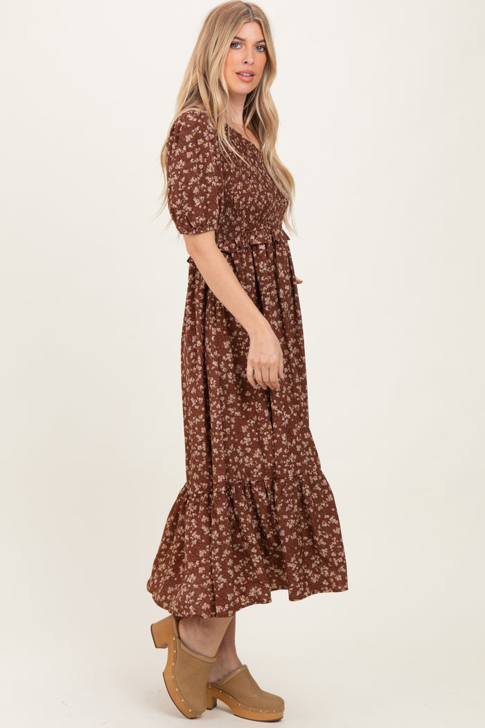 woman wearing a brown floral print maxi dress with puff sleeves and a ruffled hem