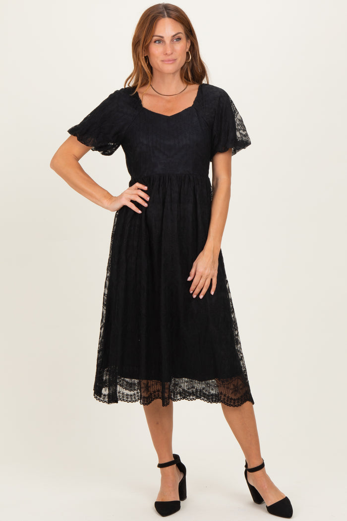 woman wearing a black lace detail midi dress with short sleeves and a square neckline