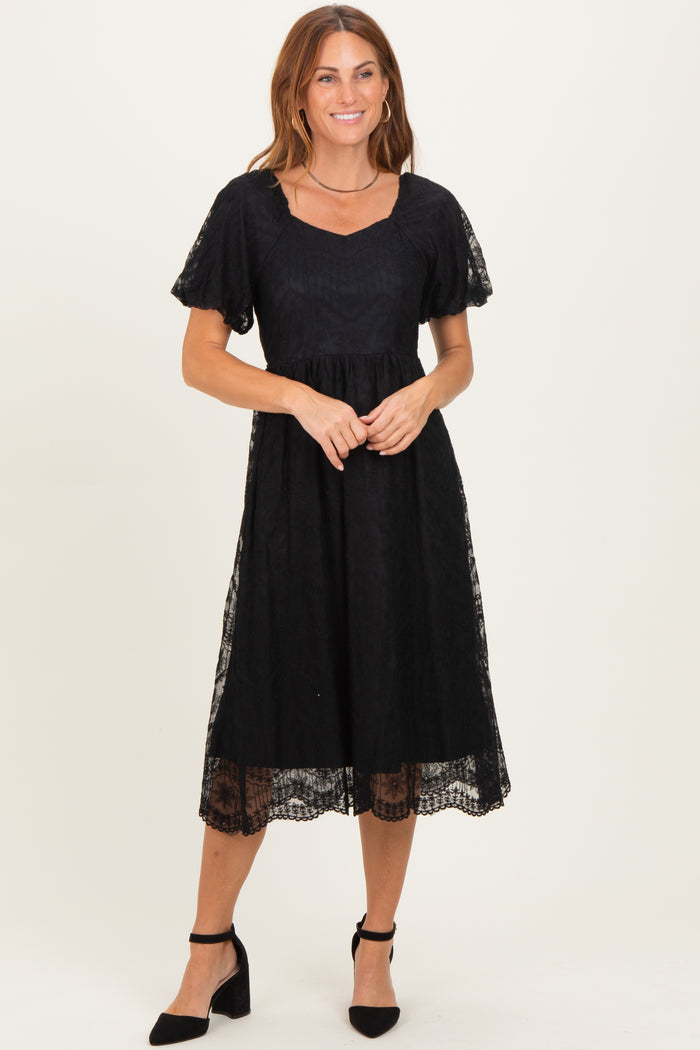 woman wearing a black lace detail midi dress with a square neckline and short sleeves