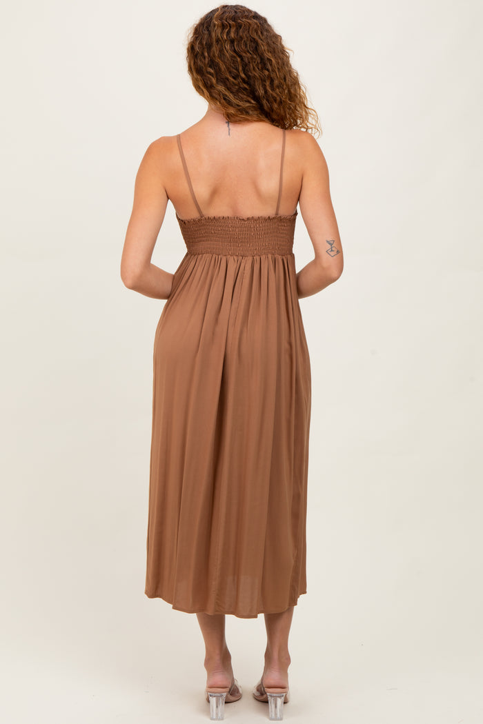 woman wearing a brown midi dress with smocked bodice and thin straps, viewed from the back