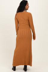 woman wearing a long sleeve ribbed maternity dress in a warm brown shade, showcasing a fitted silhouette and ankle length