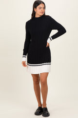 woman wearing a black ribbed sweater dress with white stripe details and long sleeves