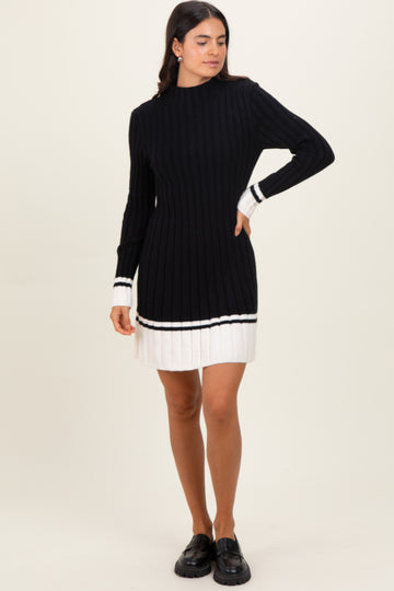 woman wearing a black ribbed sweater dress with white stripe details and long sleeves