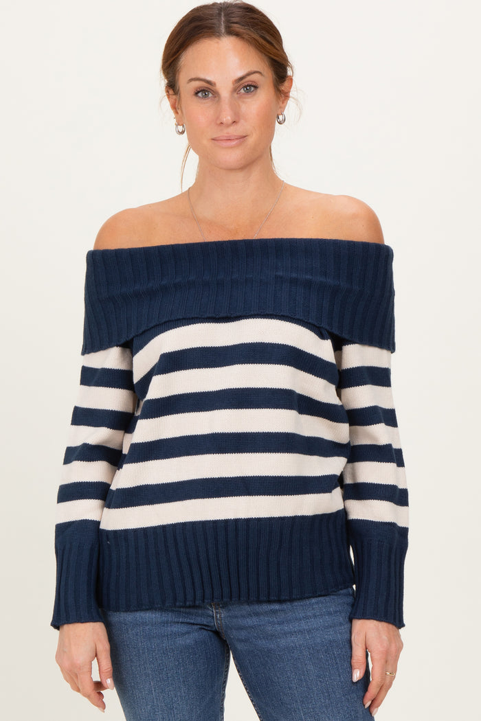 woman wearing a navy and white striped off-the-shoulder sweater paired with blue jeans