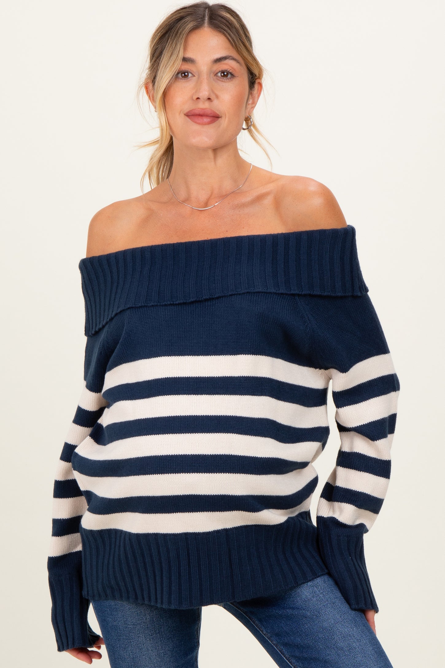 woman wearing a navy blue and white striped off-the-shoulder maternity sweater