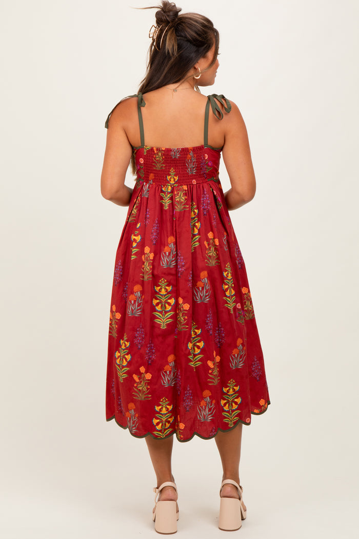 woman wearing a red floral maternity dress with tie straps and a loose fit, showing a baby bump in the back view