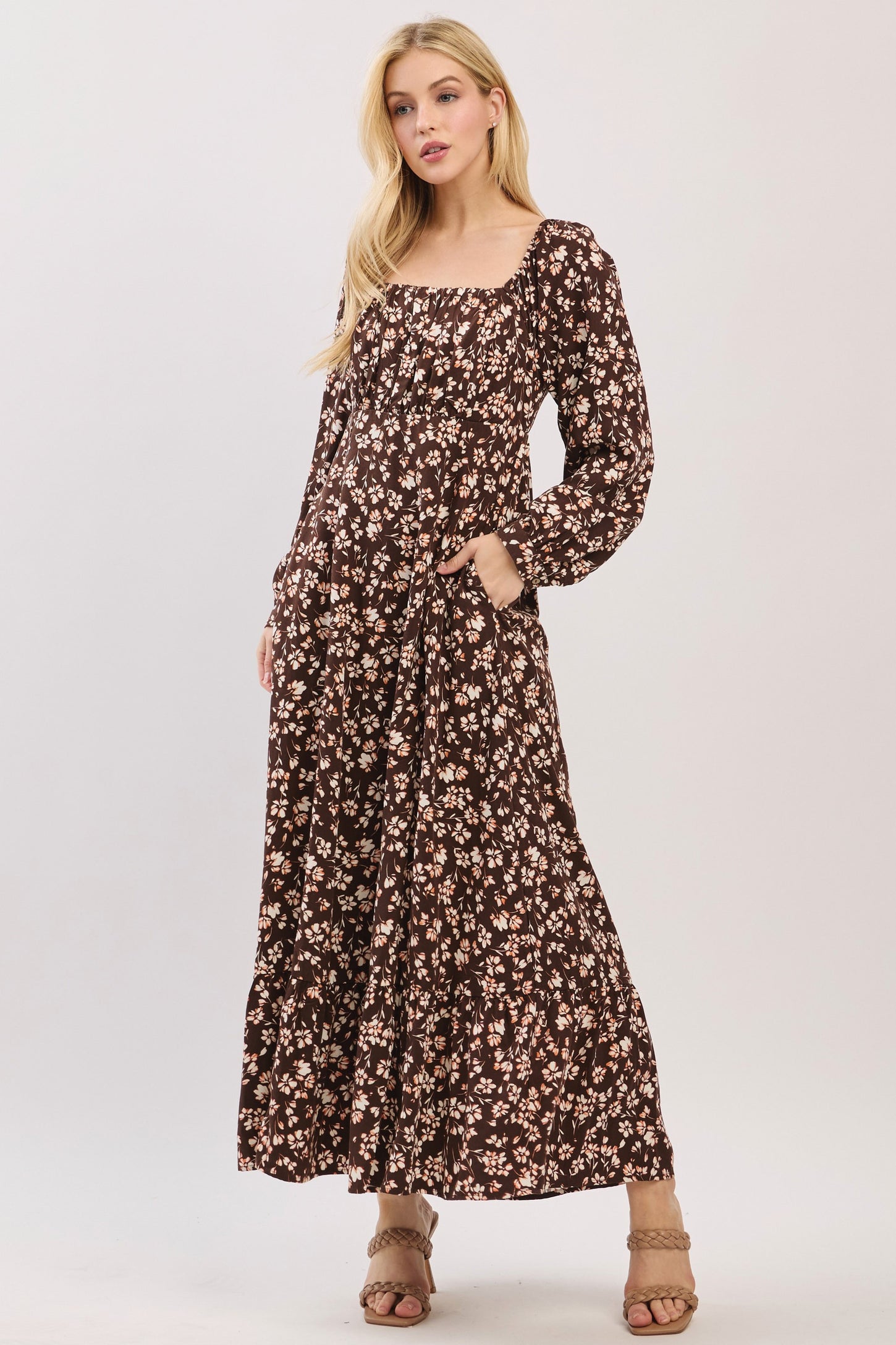 woman wearing a brown floral maxi dress with long sleeves and pockets