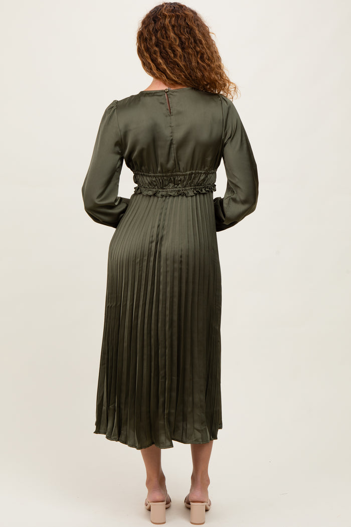 woman wearing a long olive green pleated satin dress with a fitted waist and long sleeves, shown from the back