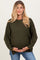 woman wearing a dark green oversized maternity sweater, holding her baby bump and paired with light blue jeans