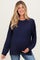 woman wearing a navy blue oversized maternity sweater with a textured pattern and holding her baby bump