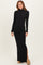 woman wearing a black long sleeve turtleneck fitted maxi dress with a thigh slit