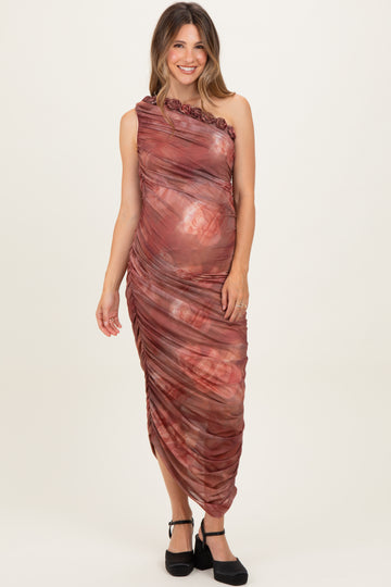 woman wearing a one-shoulder burgundy maternity dress with floral patterns and a visible baby bump