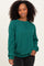 woman wearing a green ribbed long sleeve sweatshirt with a crew neck and relaxed fit