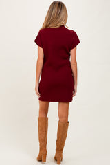 woman wearing a maroon ribbed maternity dress paired with tan knee-high boots, view from the back