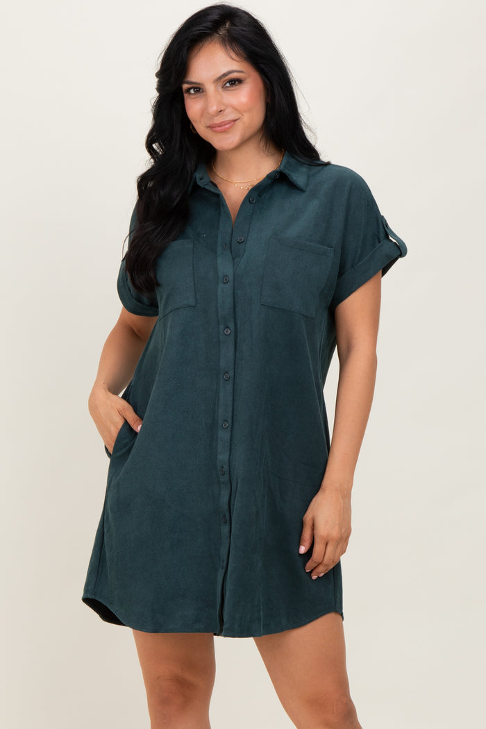 woman wearing a dark teal short sleeve button-up shirt dress with chest pockets and rolled sleeves