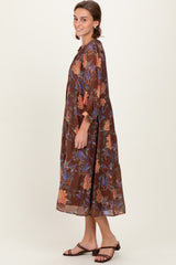 woman wearing a brown floral maxi dress with puff sleeves and tiered design paired with strappy sandals