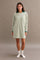 woman wearing a green oversized long sleeve dress with a dark green collar and white socks