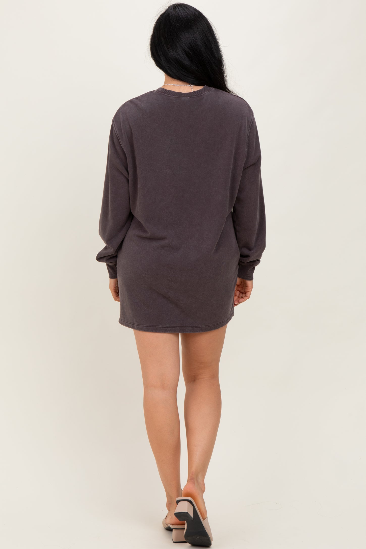 woman wearing a dark gray long sleeve oversized t-shirt dress, seen from the back