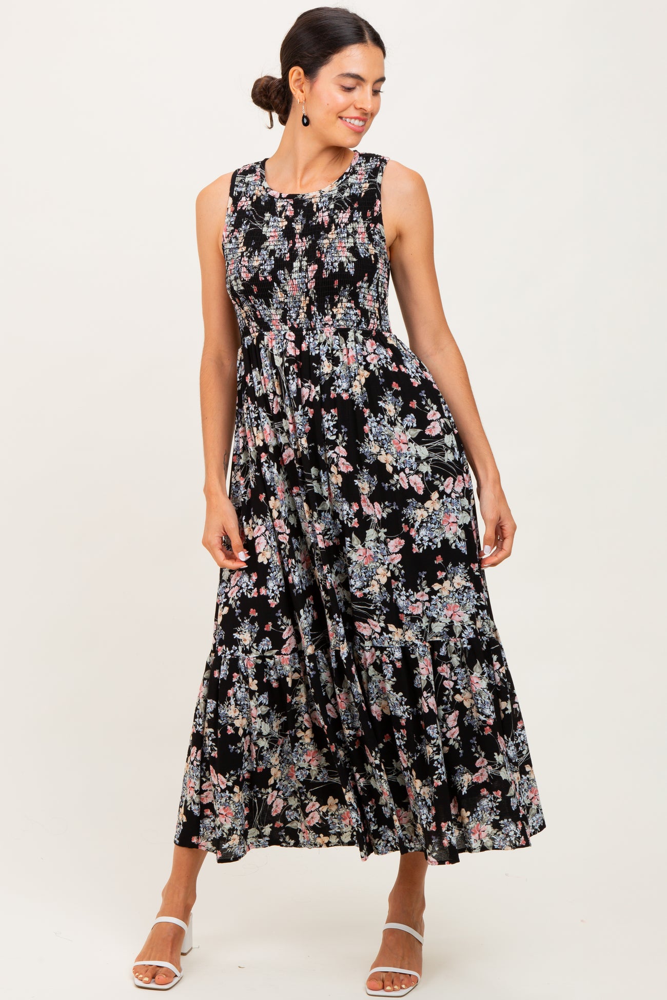 woman wearing a black floral maxi dress with a fitted bodice and flared skirt