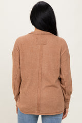 woman wearing a brown ribbed long sleeve sweater, showing the back view with a relaxed fit and dropped shoulders