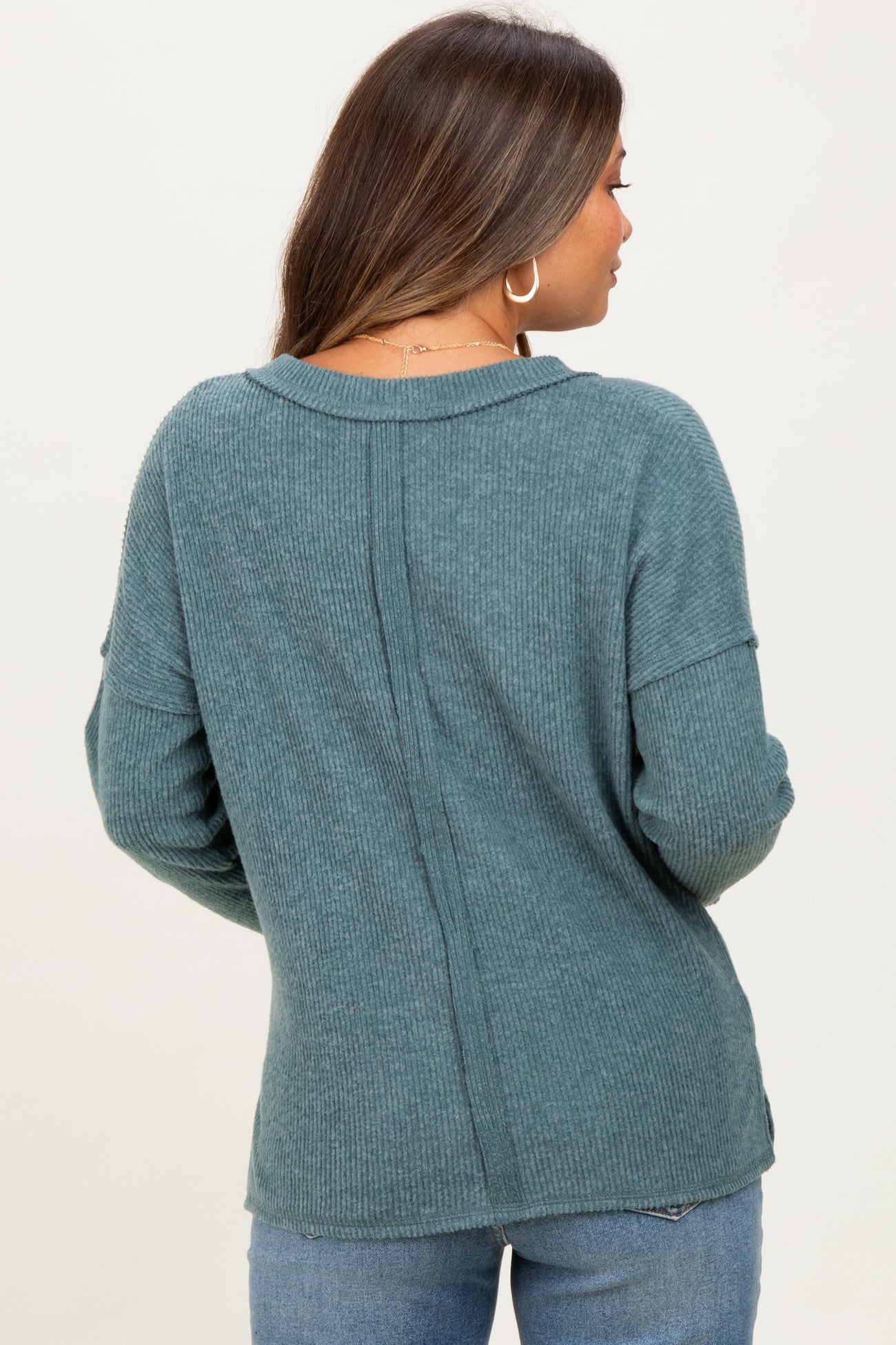 woman wearing a teal ribbed maternity sweater, view of the back, with long sleeves and a relaxed fit