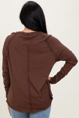 woman wearing a brown long sleeve top, showing the back with subtle seam detailing and relaxed fit