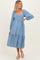 woman wearing a blue maternity dress with puff sleeves and polka dots, featuring a tiered skirt