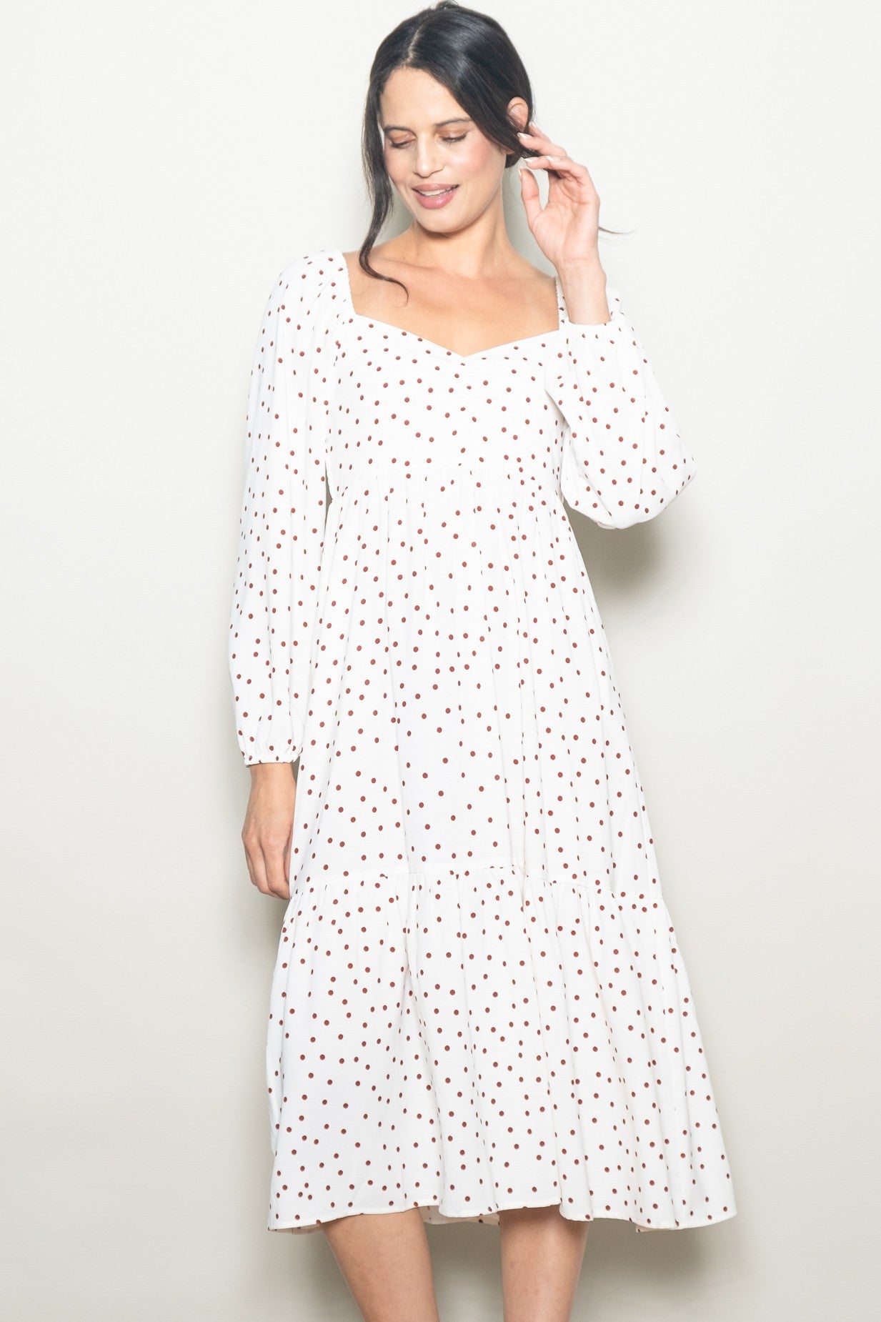 woman wearing a white polka dot midi dress with a square neckline and long sleeves
