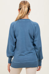 woman wearing a blue maternity sweatshirt with a relaxed fit and balloon sleeves, shown from the back