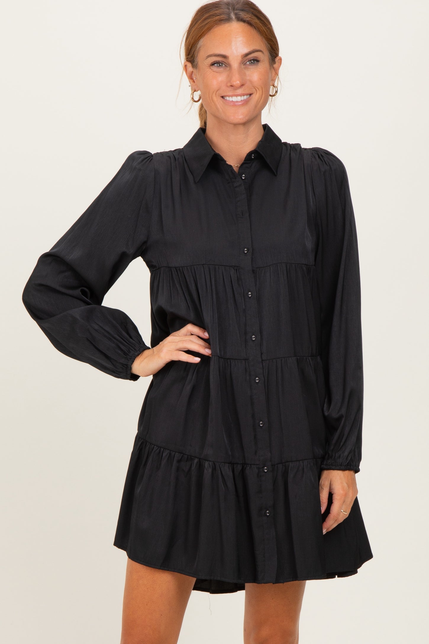 woman wearing a black button-up tiered dress with long sleeves and a collared neck