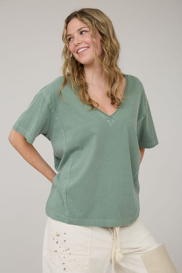 woman wearing a green v-neck oversized t-shirt with short sleeves and a relaxed fit
