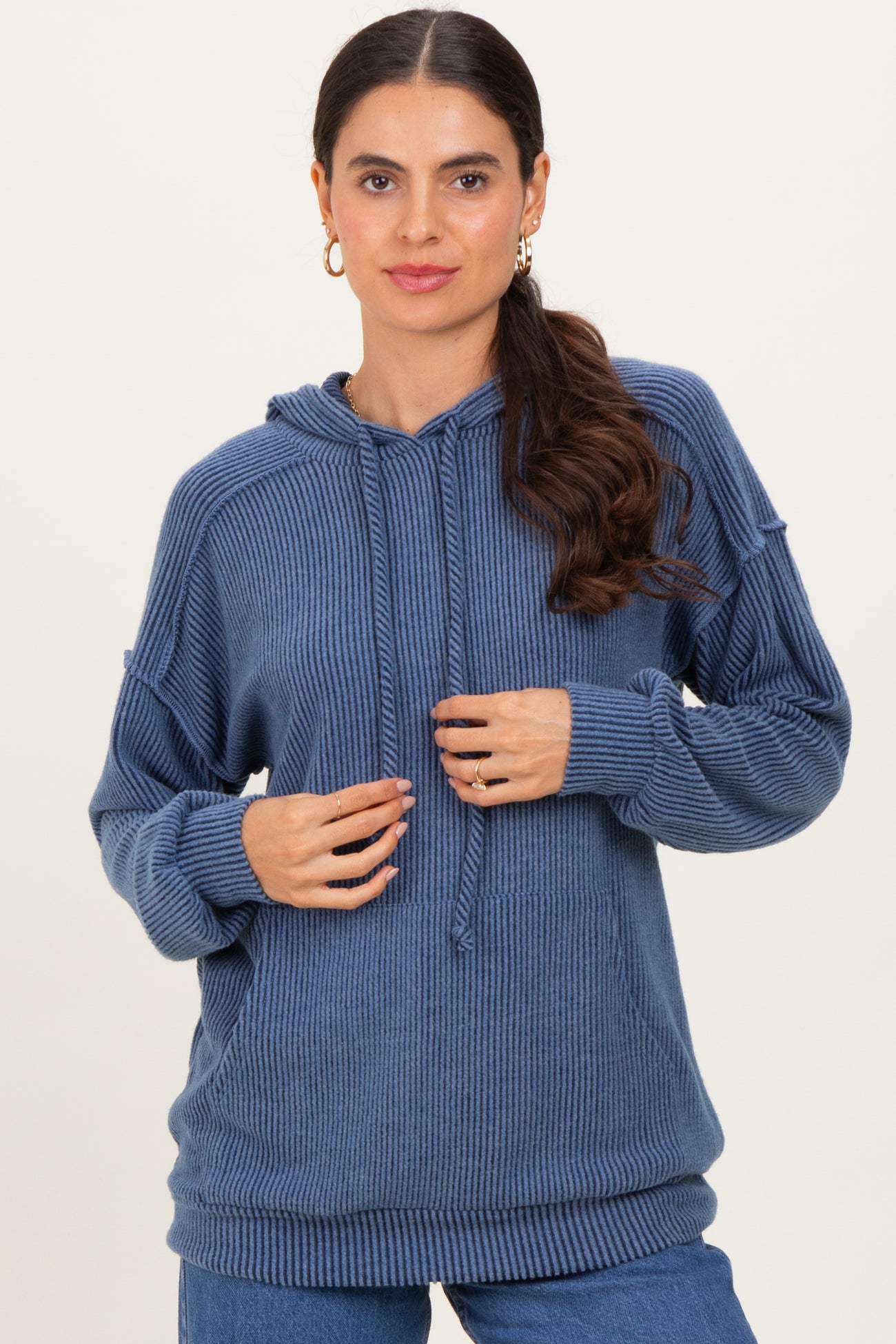 woman wearing a dark blue ribbed hoodie with a drawstring and a relaxed fit