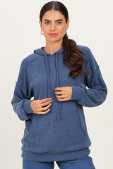 woman wearing a dark blue ribbed hoodie with a drawstring and a relaxed fit