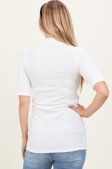woman wearing a white ribbed short sleeve top viewed from the back with long blonde hair