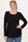woman wearing a black long sleeve top with a gathered waist and round neckline, smiling and posing with hands on hips