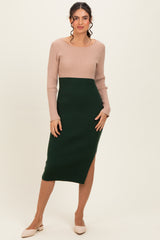 woman wearing a color-block ribbed knit midi dress with a tan top and dark green bottom, featuring a side slit