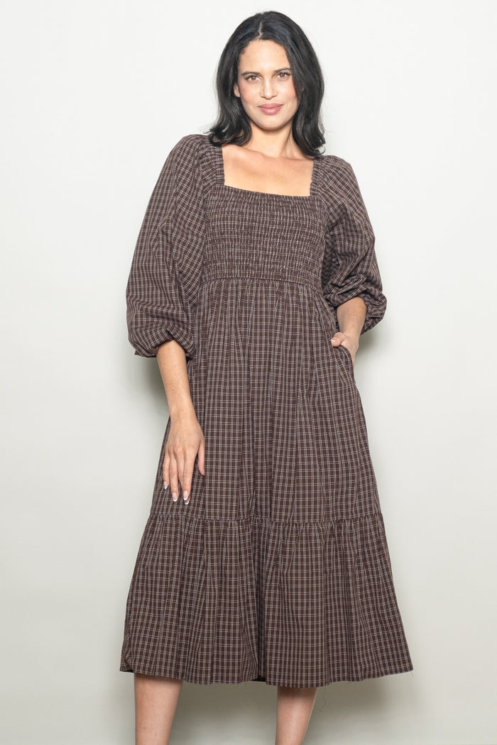 woman wearing a brown checkered midi dress with a square neckline and puff sleeves
