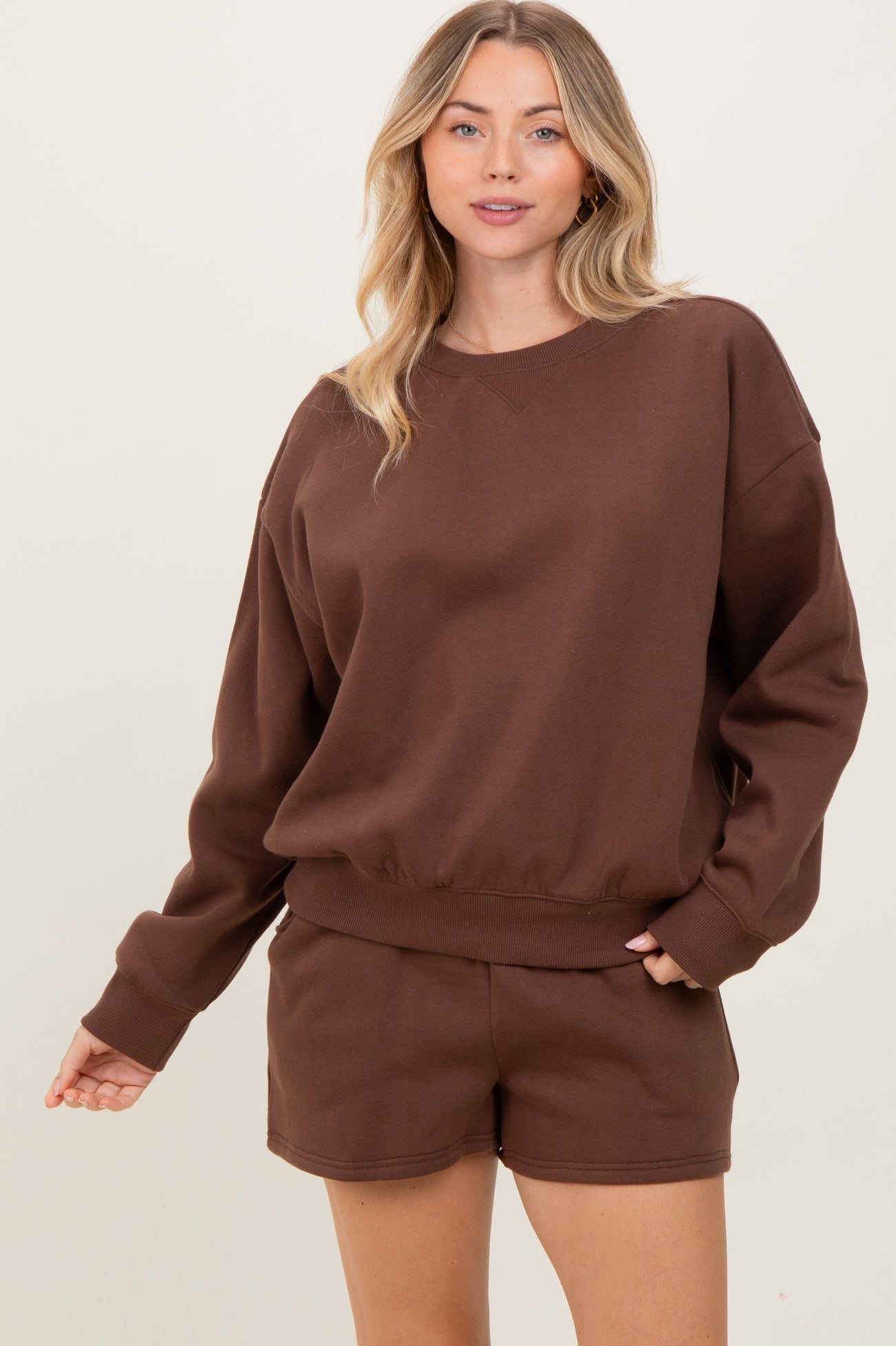woman wearing a brown oversized sweatshirt and matching shorts