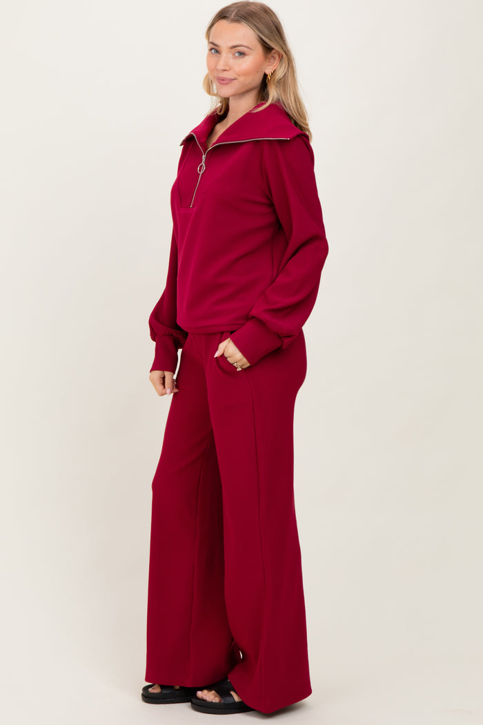 woman wearing a burgundy zip-up pullover and matching wide-leg pants