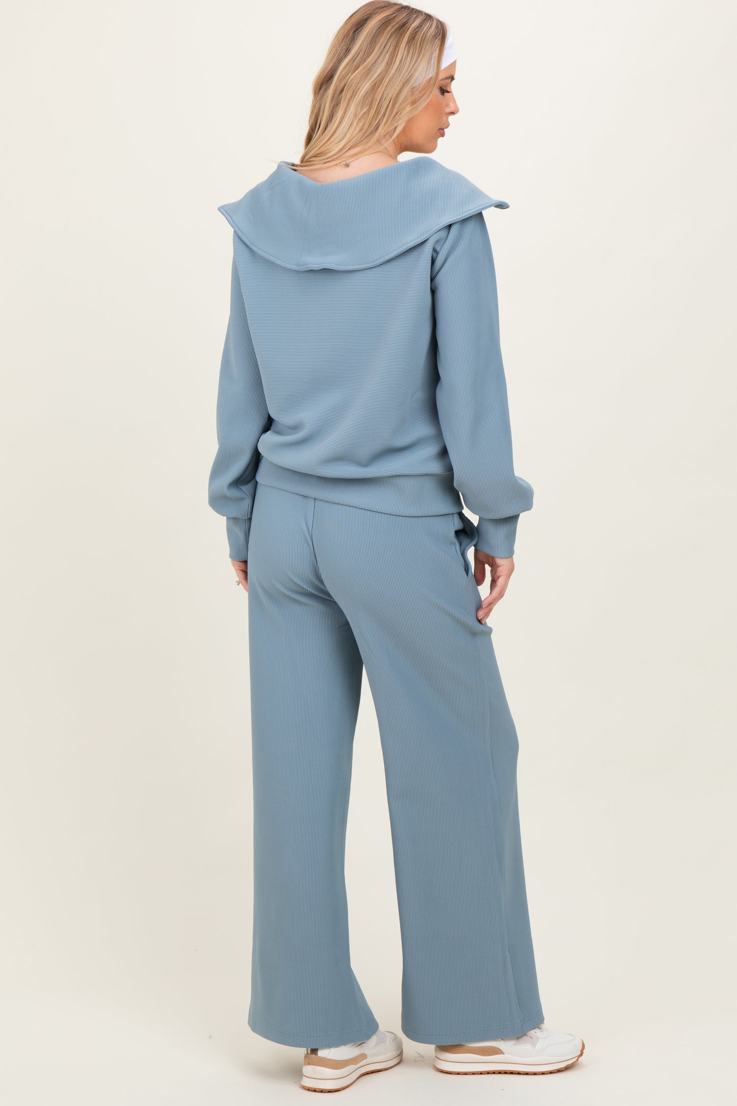 woman wearing a light blue ribbed matching lounge set with a shawl collar and wide-leg pants