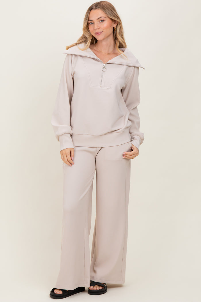 woman wearing a light beige zip-up hoodie and matching wide-leg pants in a ribbed fabric