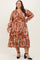 plus-size woman wearing a colorful printed long sleeve dress with a v-neckline and tiered skirt