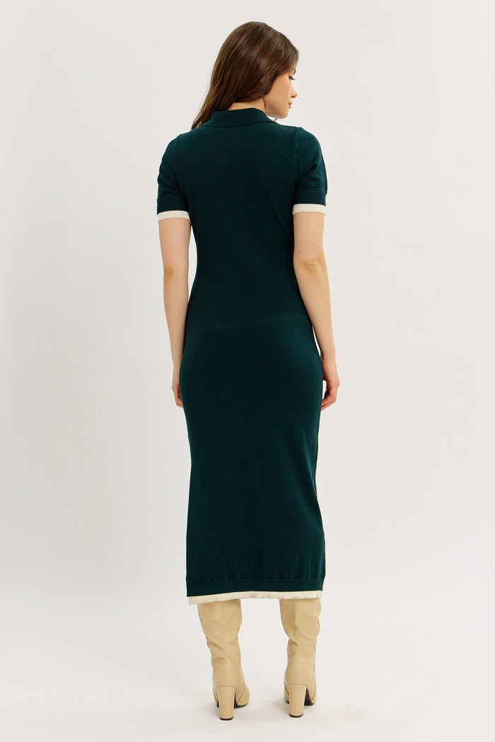 woman wearing a dark green short sleeve knit dress with contrasting white collar and hem, seen from the back