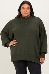 woman wearing an oversized olive green ribbed sweater with a high neckline and relaxed fit, posing confidently